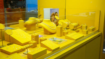 Yellow jewelry displayed in a brightly lit store window.