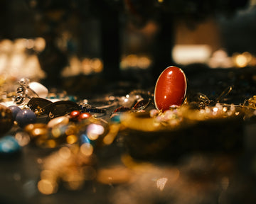 A red oval object stands amidst sparkling jewelry