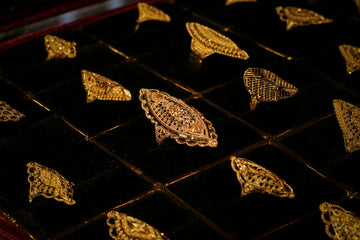 Intricate gold rings displayed in a black velvet jewelry tray